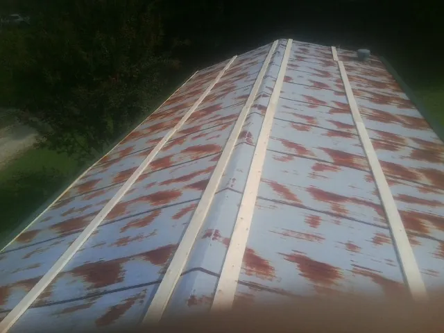 Rusted metal roof panels with new wood purlins before replacement — Storm Damage Roof Repair in Riceboro by Roofing Brothers