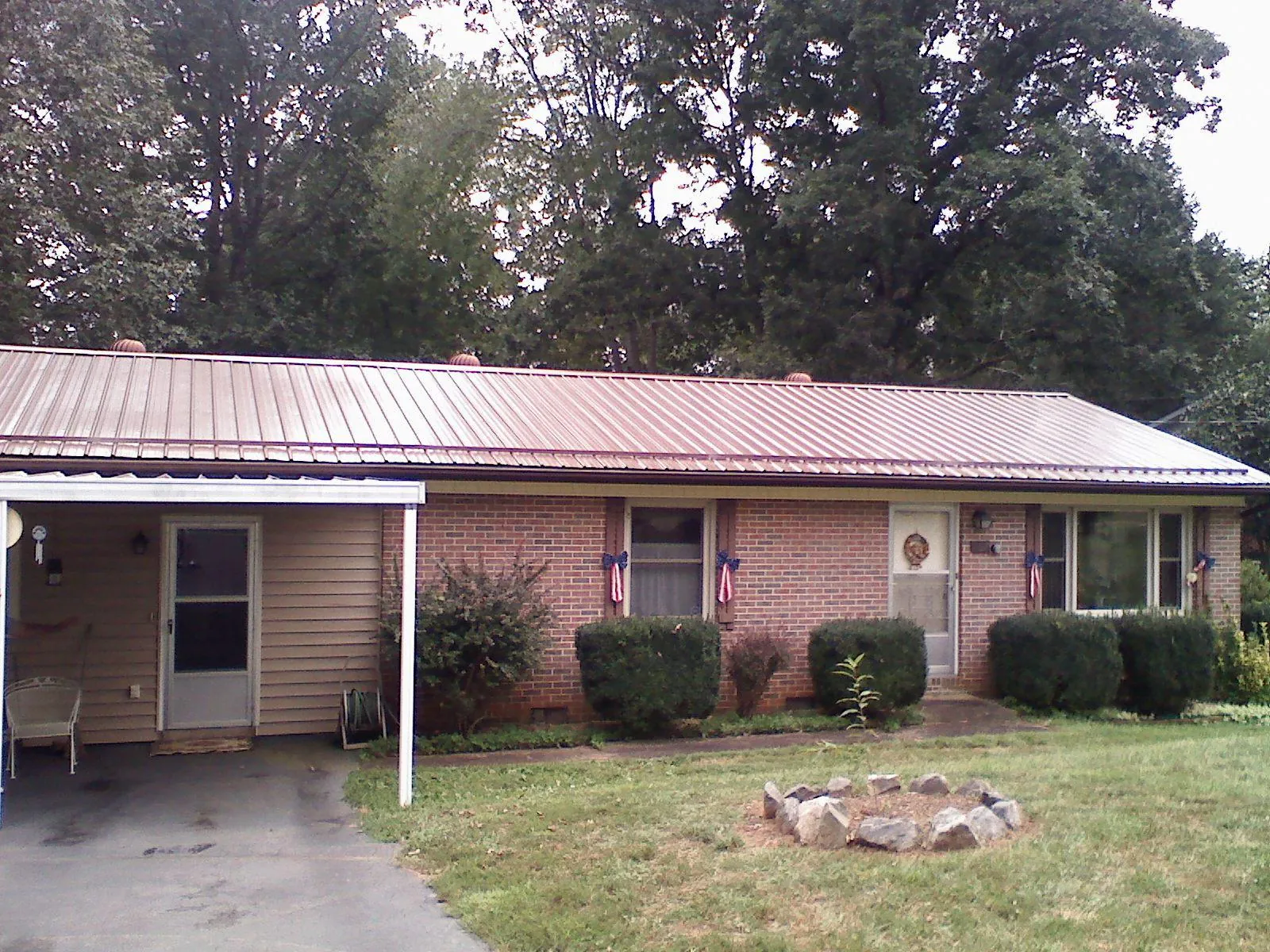 Bronze metal roof and carport on a brick ranch home — Roof Repair work by our crew in Riceboro