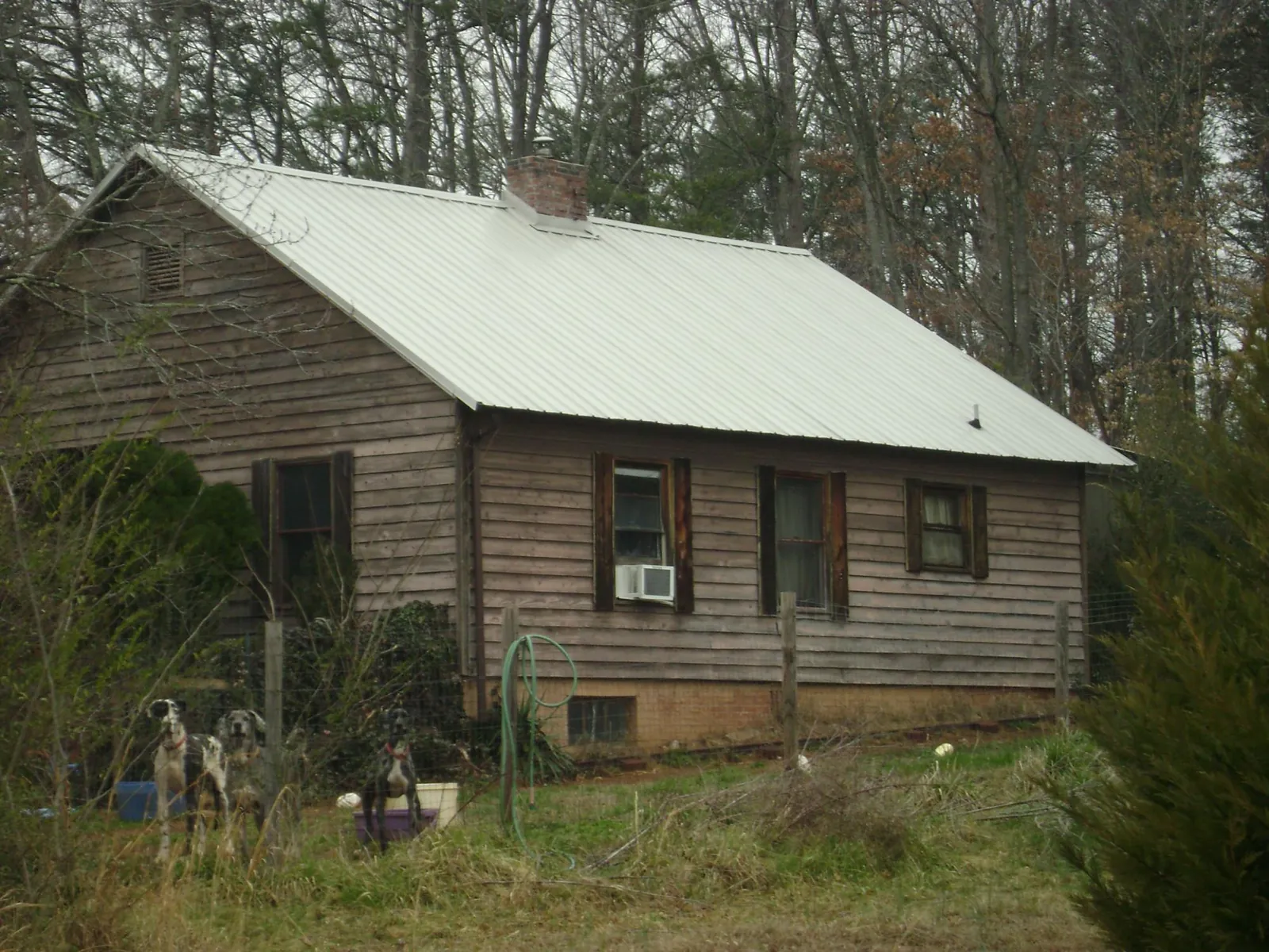 White metal roof on an old wood sided farmhouse, from a Metal Roof Installation job in Riceboro